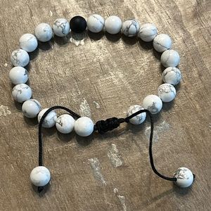 White beaded bracelet with one black bead-unisex
